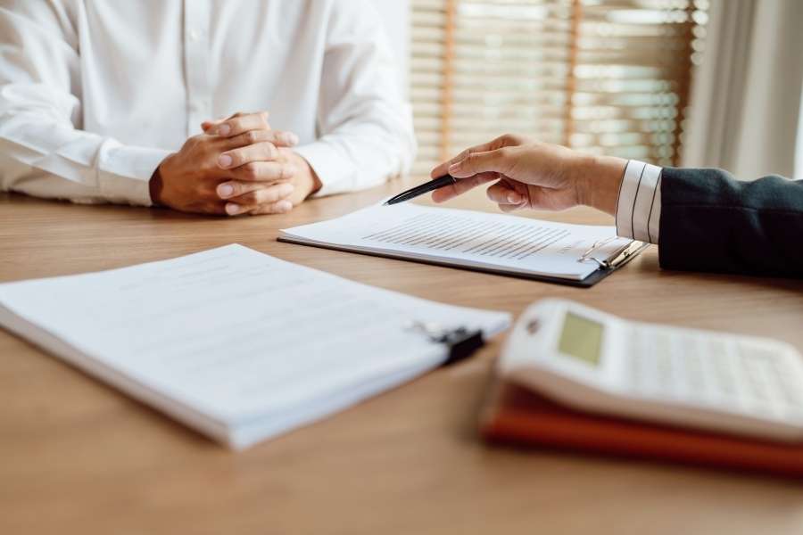 Une personne présente un contrat à un client pour gérer un sinistre efficacement.