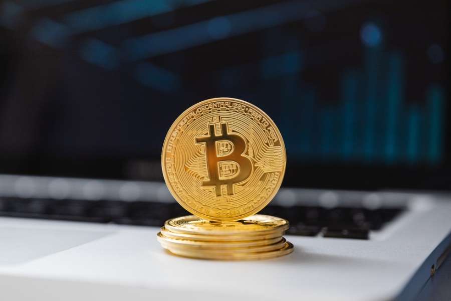 Une pièce physique de Bitcoin posée sur un clavier d'ordinateur pour illustrer le premier achat de cryptomonnaie.